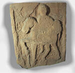 Unfinished tombstone bearing a full length representation of a horse and rider.